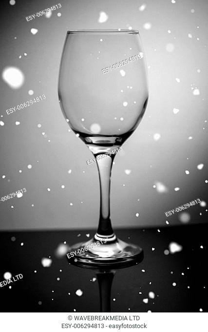 Snow falling against empty wine glass