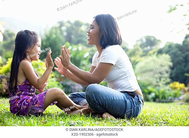China, Hong Kong, Mother and daughter (8-9) playing in garden