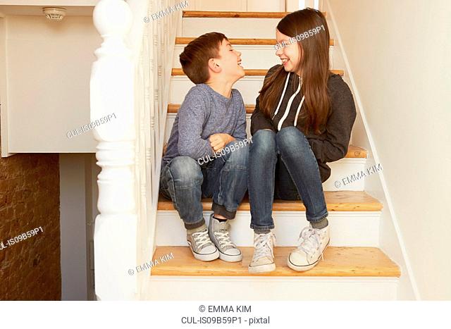 Boy and sister chatting on stairs