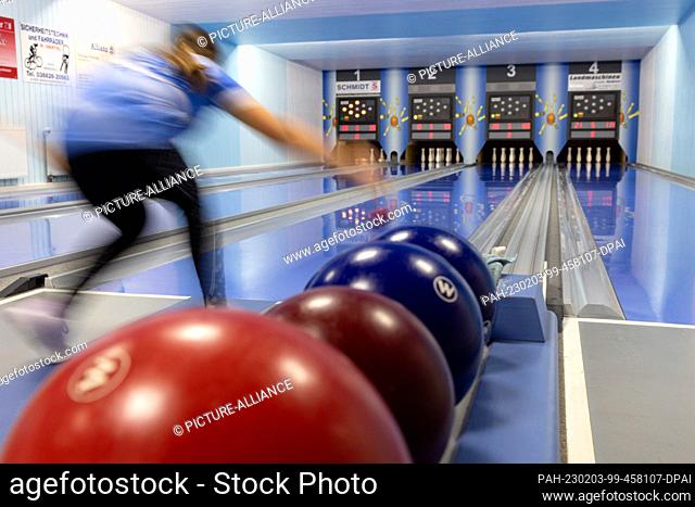 PRODUCTION - 25 January 2023, Thuringia, Auma-Weidatal: A junior player pushes a ball onto the bowling alley at the SV Blau-Weiß Auma clubhouse