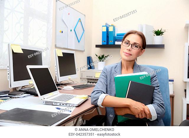 Portrait of a business woman at work, long hours of work in the office, clever and serious secretary, professional of her job, successful life of a young people
