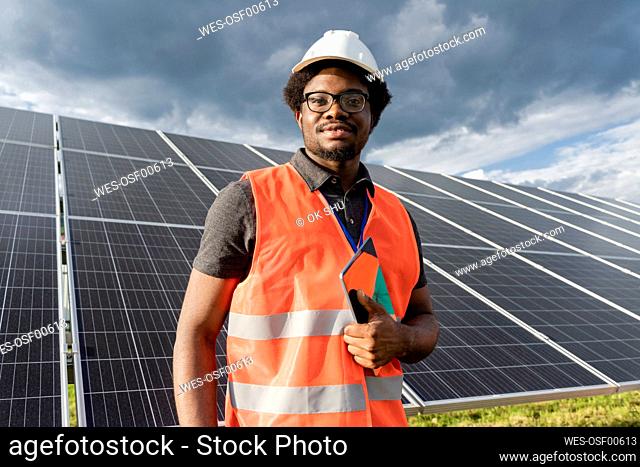 Engineer holding tablet PC at solar station