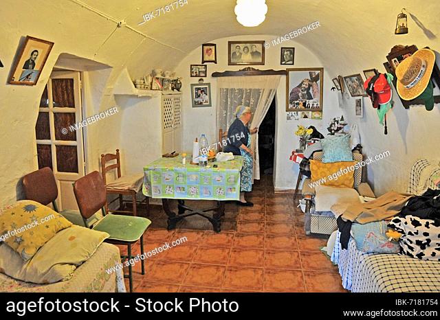 Insight into living space of an inhabited cave dwelling, woman in living room of a cueva, wall decoration, wall kitsch, individual living, architecture