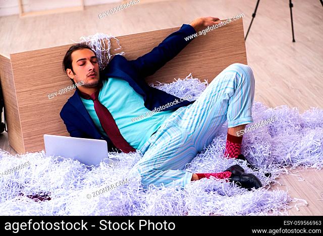 Young businessman employee and a lot of cut papers in the office
