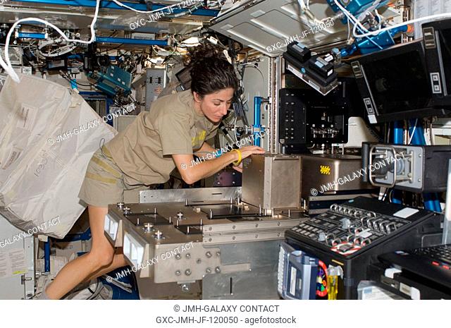 NASA astronaut Nicole Stott, Expedition 21 flight engineer, installs hardware in the Fluids Integrated Rack (FIR) in the Destiny laboratory of the International...