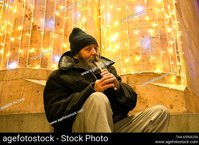 ARMENIA, YEREVAN - DECEMBER 19, 2023: A man plays the duduk during a ceremony to light up Yerevan's main Christmas tree in Republic Square