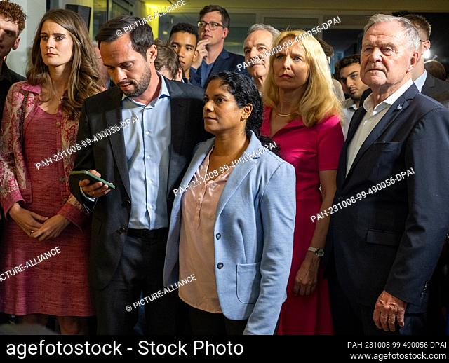 08 October 2023, Bavaria, Munich: Martin Hagen (FDP, l), Bavarian state chairman, looks at the forecasts with his wife Anisha and state parliament candidates...