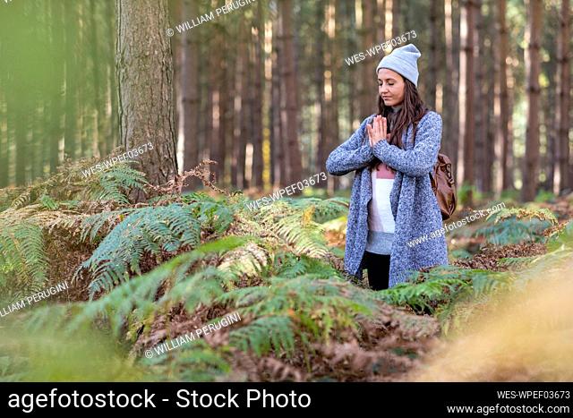 Female hiker doing yoga while standing in Cannock Chase woodland