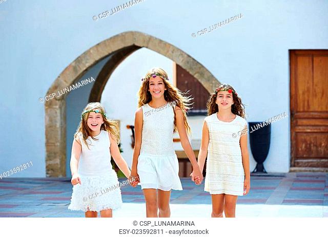 Kid girls walking hand in hand Mediterranean village