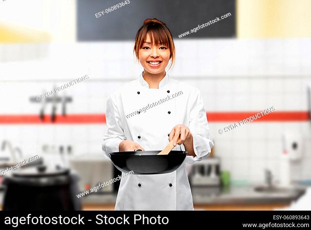 smiling female chef with frying pan on kitchen