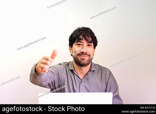 Businessman reaching out his hand for a handshake in the office