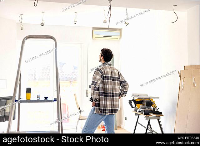 Young man looking at living room being renovated
