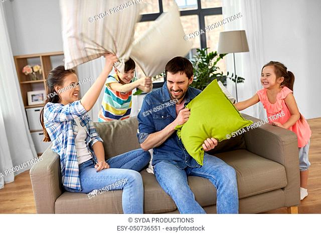 happy family having pillow fight at home