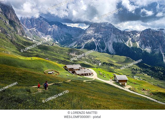 Italy, Dolomites, Odle mountain range, Hikers heading to a chalet