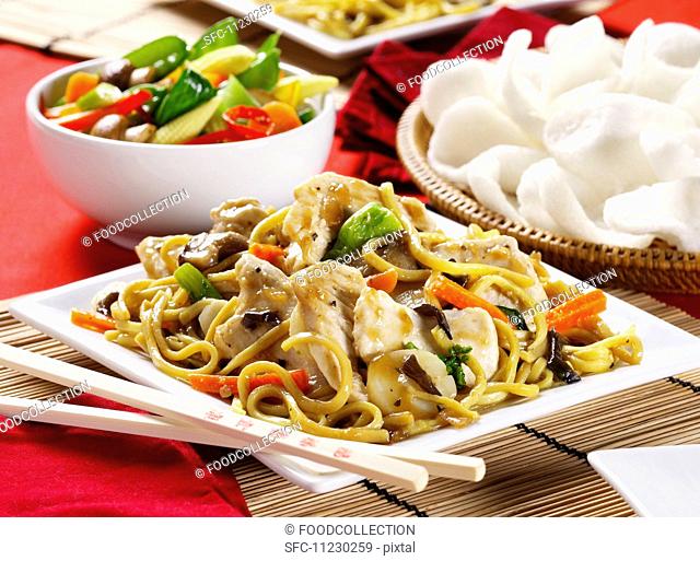 Fried noodles with chicken, vegetable salad and prawn crackers (China)