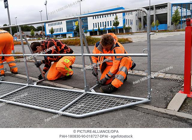 30.08.2018, Saxony, Chemnitz: Workers erect barriers from the Chemnitz stadium. A demonstration of the right-wing populist movement Pro Chemnitz is to take...