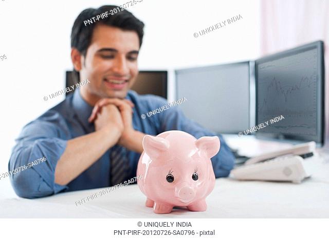 Businessman looking at a piggybank