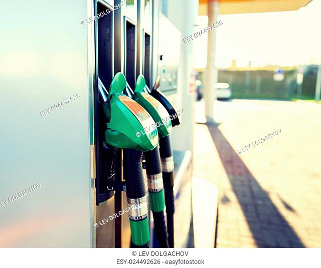 object, fuel, oil, tank and transport concept - close up of gasoline hose at gas station
