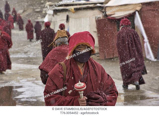 Tibetan nun walking in the snow, Yarchen Gar, Sichuan, China