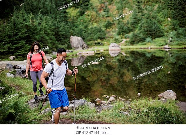 Couple hiking along lake in woods