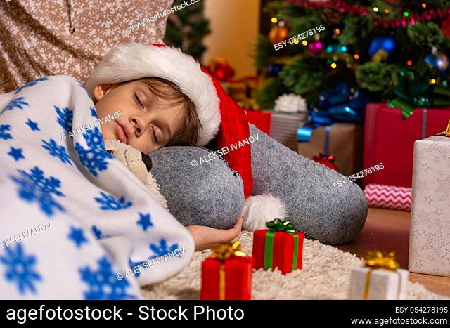 Girl lies on mom's lap at Christmas tree