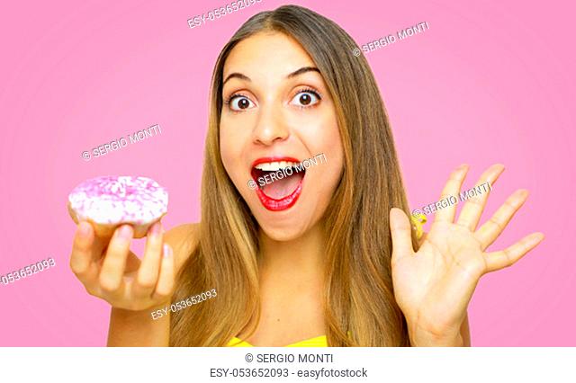 Excited funny cheerful girl holding donut on pink backgrond
