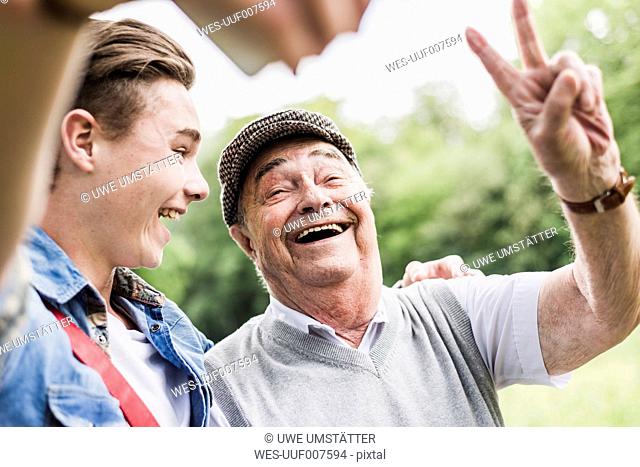 Grandfather and grandson taking selfie with smartphone