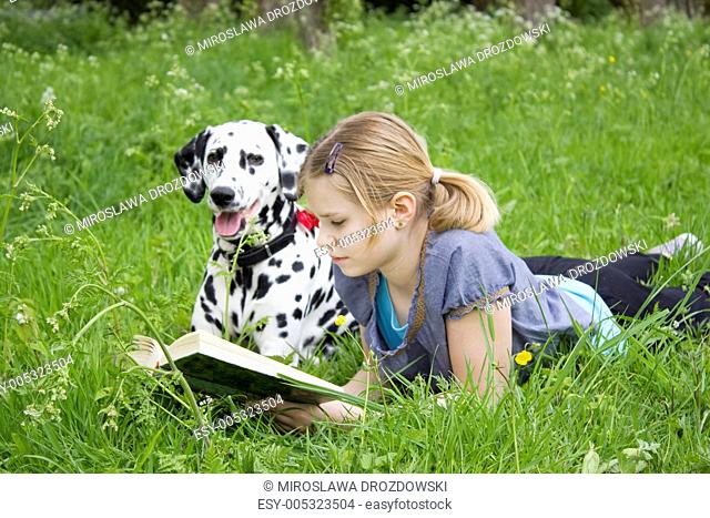 A little girl reading a book outdoor