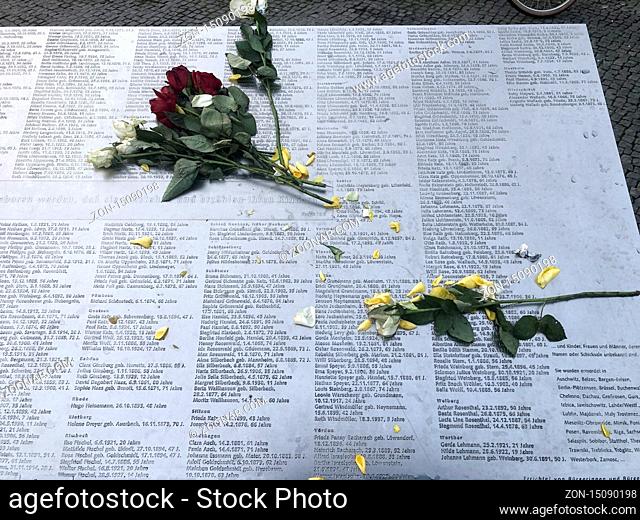 Rosen liegen zum Jahrestag der Reichspogromnacht auf der gedenkplatte mit den Namen der im Dritten Reich aus Bielefeld deportierten Jüdinnen und Juden / roses...