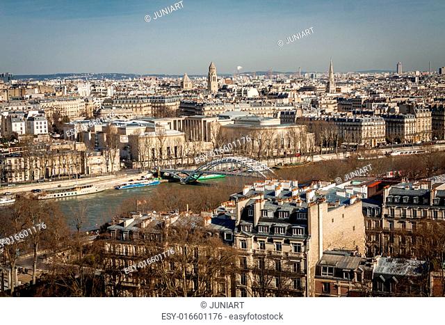 View over the rooftops of Paris, France with its streets of historical buildings to a distant skyline under a blue sky, travel concept