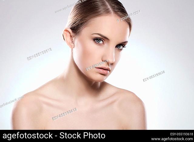 Portrait of beautiful woman with clean face over grey background