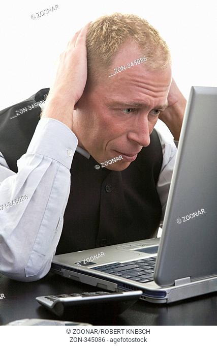 Programmierer grübelt vor seinem Laptop an einer komplizierten Aufgabe