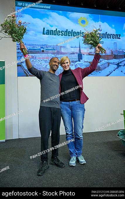 13 December 2023, Berlin: Philmon Ghirmai (Bündnis90/Die Grünen), state chairman, and member of the Bundestag Nina Stahr (Bündnis90/Die Grünen) hold flowers and...