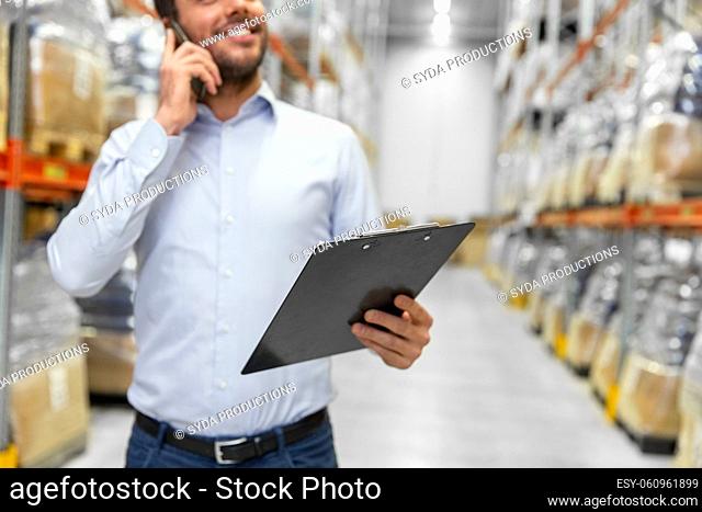 businessman calling on smartphone at warehouse
