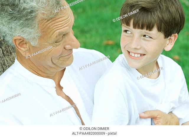 Grandfather and grandson smiling at each other, portrait