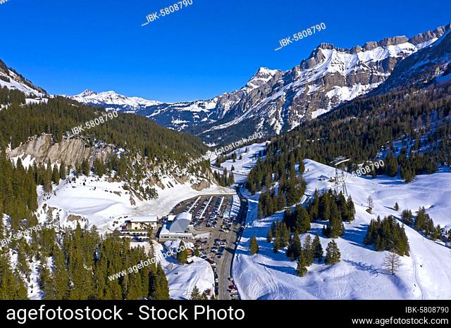 Car park and valley station of the Glacier 3000 aerial cableway to the Glacier des Diablerets ski area on the Col du Pillon mountain pass in winter, Gstaad