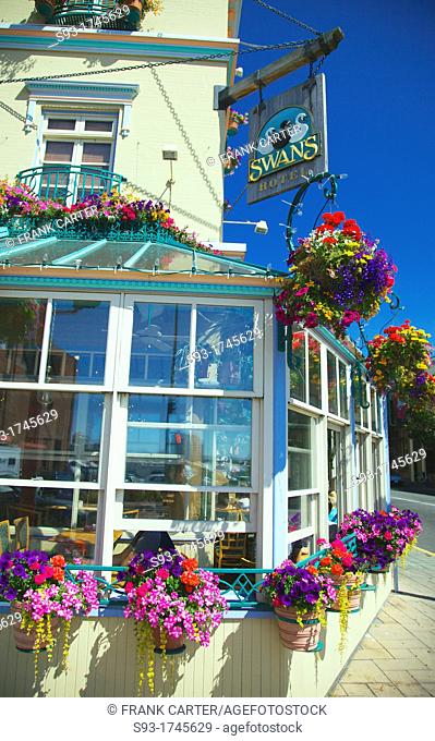 A view of the Swan Hotel in downtown Victoria showing hanging flower pots all around it
