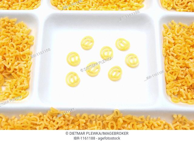 Letters made of pasta sorted and unsorted with special character @, plate