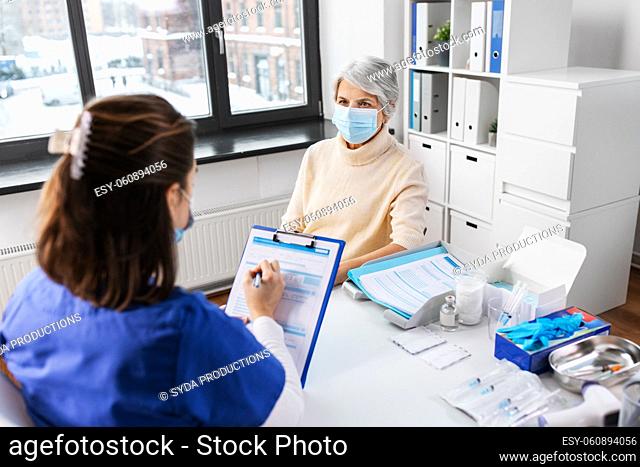 doctor with clipboard and senior woman at hospital