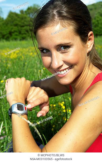 young woman running with pulse watch