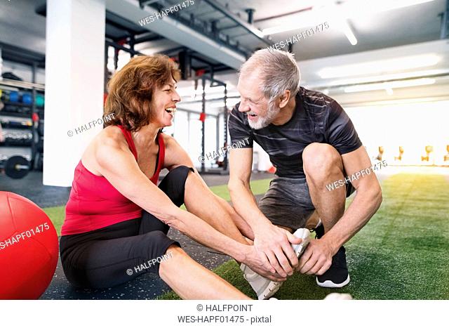 Happy senior couple exercising in gym