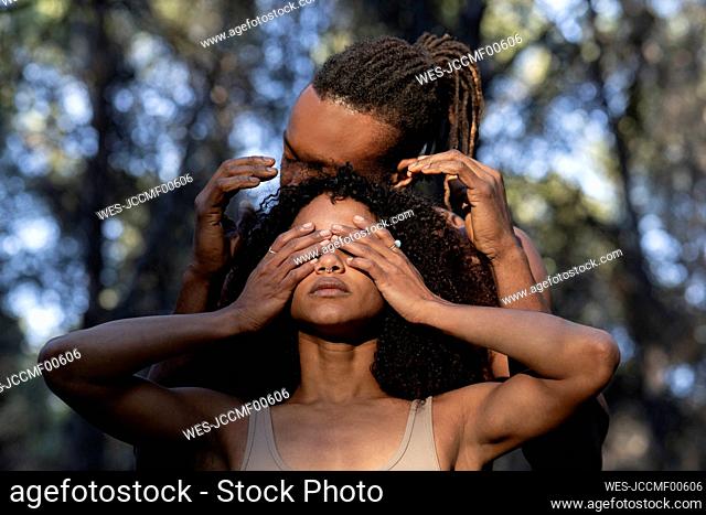 Female dancer covering eyes during performance with male partner
