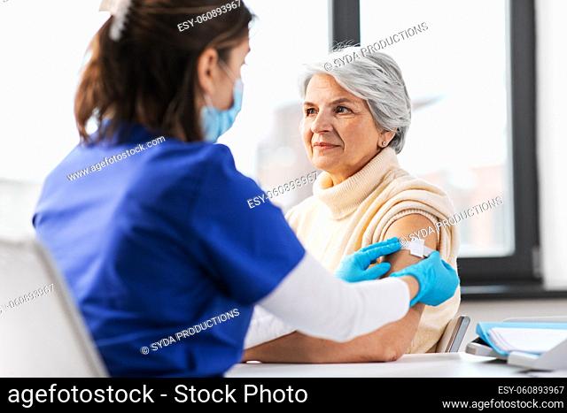 nurse applying medical patch to vaccinated woman