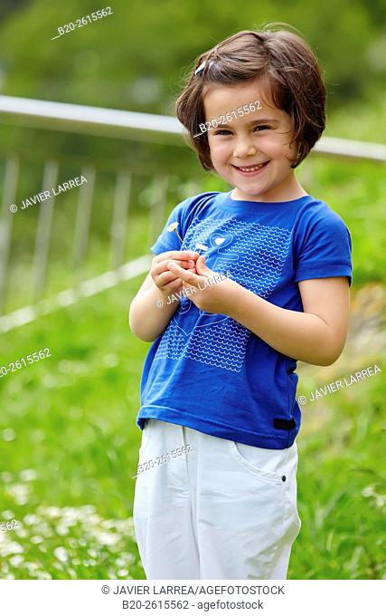 Little girl picking flowers in grass