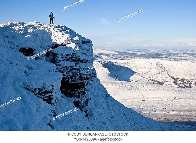 Hiker enjoys scenic winter view from summit of Corn Du, Brecon Beacons national park, Wales