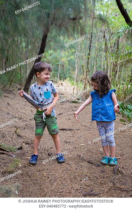 Brother and sister having fun on the Hauula Loop Trail while hiking in Oahu Hawaii