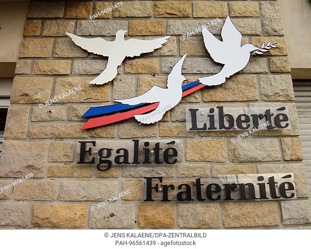 The words Liberté, égalité, fraternité (lit. liberty, equality, fraternity) and peace doves attached to a wall of the town hall in Crozon (France)