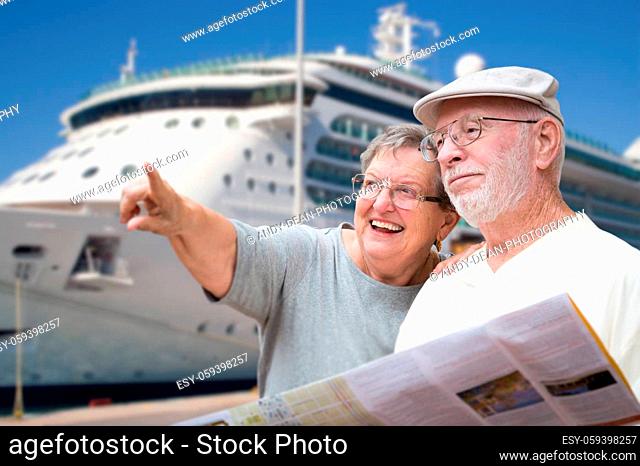 Happy Senior Adult Couple Tourists with Brochure Next To Passenger Cruise Ship
