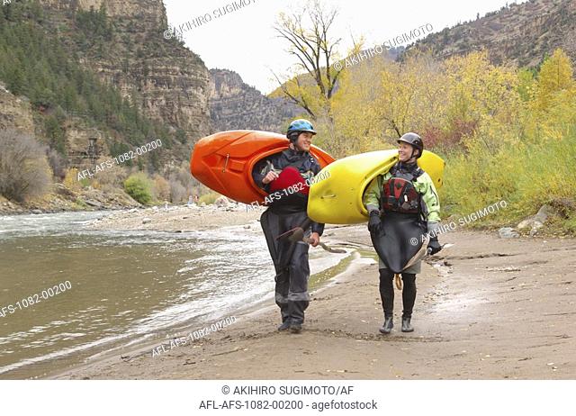 Two Kayakers Carrying Their Kayaks