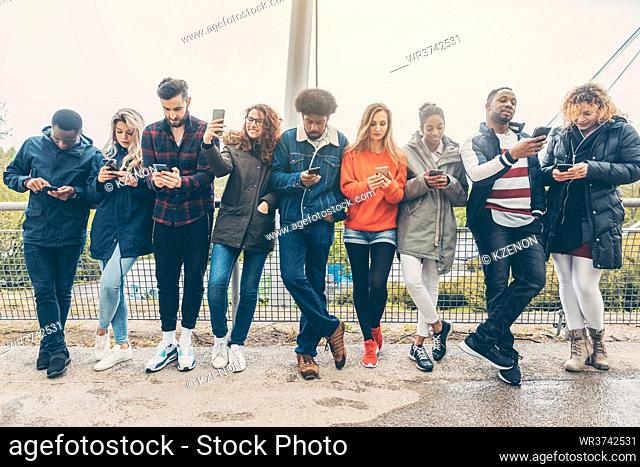 Group of young people staring on their phones avoiding other forms of social contact